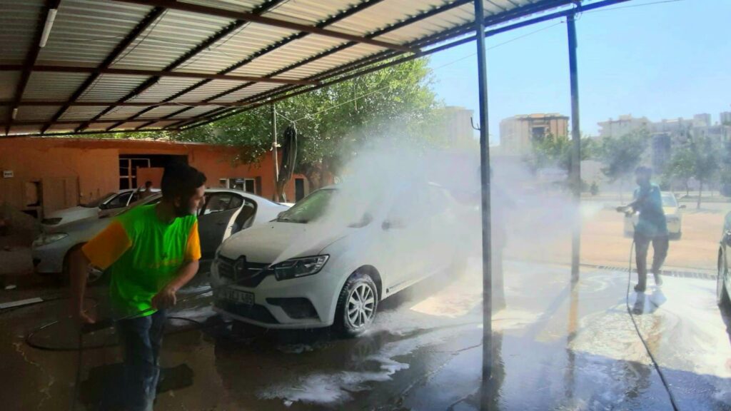 İşçiler sıcak havada tazyikli suyla serinliyor