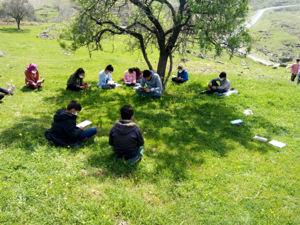 Öğrenciler güneşli havada okuma şenliğinde kitap okudu